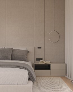 Calm bedroom with upholstered wall panels and circular pendant light
