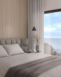 Bedroom with soft grey bed and panoramic sea view