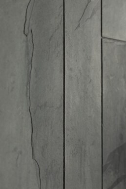 Фактура темного натурального сланцю на стіні вітальні / Texture of the dark natural slate wall in the living room