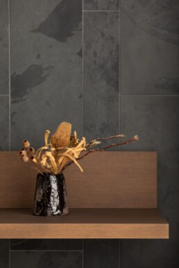 Сухоцвіти на дерев&rsquo;яній полиці біля сланцевої стіни / Dried flowers on a wooden shelf beside the slate wall
