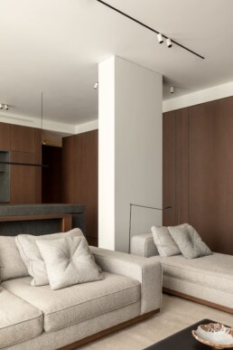 М&rsquo;яка зона вітальні з колоною та видом на кухню / Living room seating area with a column and a view towards the kitchen