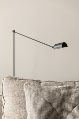 Настінний світильник для читання над фактурним диваном / Wall-mounted reading light above a textured sofa