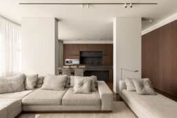 Вітальня, що переходить у кухню з дерев&rsquo;яними фасадами / Living room opening into the kitchen with wood cabinetry