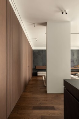Прохід уздовж кухні до вітальні, обшитий дерев&rsquo;яними панелями / Wood-paneled passage from the kitchen towards the living room