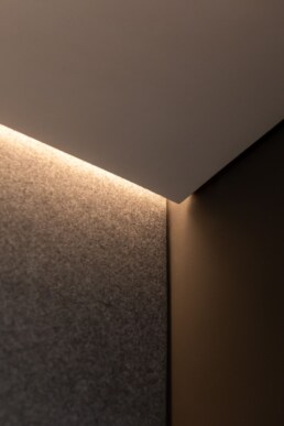 Приховане стельове підсвічування над сірою стіною / Concealed ceiling lighting above a gray wall