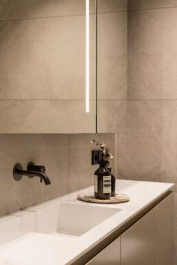 Вбудована біла раковина та чорний настінний змішувач / Integrated white basin and black wall-mounted faucet