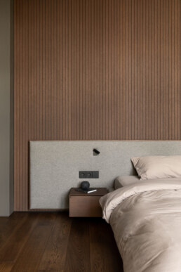 Спальня з м&rsquo;яким ліжком і рейковою дерев&rsquo;яною стіною / Bedroom with an upholstered bed and slatted wood wall