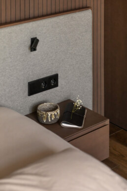 Приліжкова тумба, світильник і втоплені в дерево вимикачі / Bedside table, reading light and switches recessed into wood