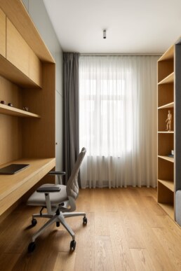 Дитяча робоча зона з дерев&rsquo;яним столом і полицями біля вікна / Child&rsquo;s study area with a wood desk and shelves by the window