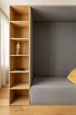 Відкриті дерев&rsquo;яні полиці поруч із м&rsquo;якою сірою нішею / Open wood shelves beside a soft gray alcove